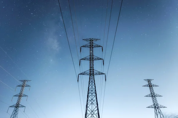 Hoogspanning electriciteit pyloon 's nachts. — Stockfoto