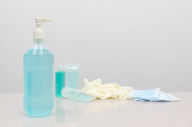 Coronavirus Önleme Ekipmanı, Tıbbi Maske El dezenfektanı ve tıbbi eldivenler beyaz masada. Diğerlerine hastalığın yayılmasını önlemek için bir kampanya mesajı eklemek için boş alan..