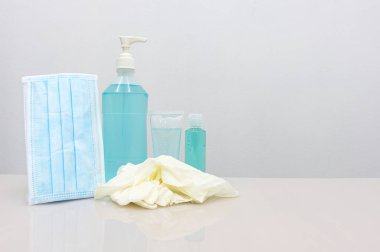 Coronavirus Önleme Ekipmanı, Tıbbi Maske El dezenfektanı ve tıbbi eldivenler beyaz masada. Diğerlerine hastalığın yayılmasını önlemek için bir kampanya mesajı eklemek için boş alan..