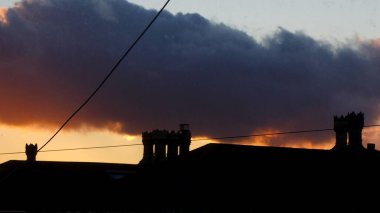 Şehrin gün batımında Bristol 'da baca ve çatı. 