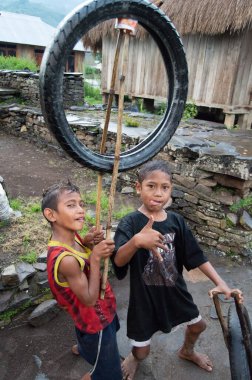 Kelimutu, Doğu Nusa Tenggara / Endonezya - 13 Ocak 2015: Geleneksel bir köyde tekerlekle oyuncak gibi oynayan bir çocuğun portresi.