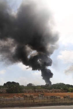 Bir araba yangınından çıkan büyük bir duman sütunu