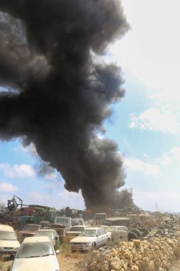 Bir araba yangınından çıkan büyük bir duman sütunu