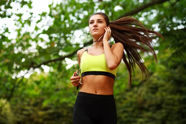 Ung kvinna körs i grön park, fitness utomhus — Stockfoto