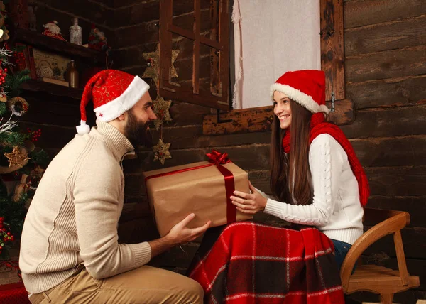 Ungt par i semesterboende i jul presenterar gåvor — Stockfoto
