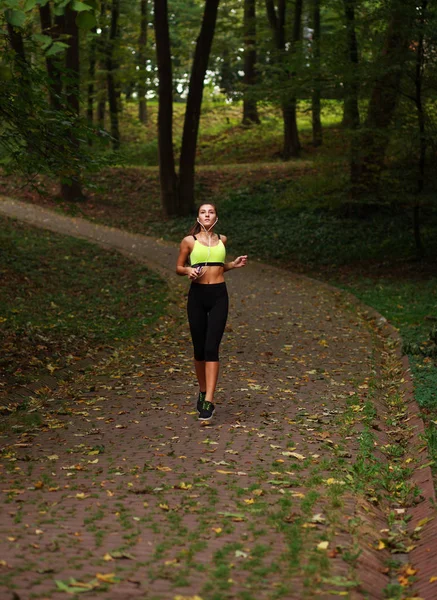 Женщина бегает в зеленом парке, здоровый образ жизни — стоковое фото