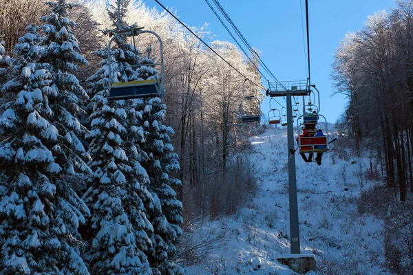 Winter mountain lift for skiers above snowy forest and sky — Stock Photo, Image