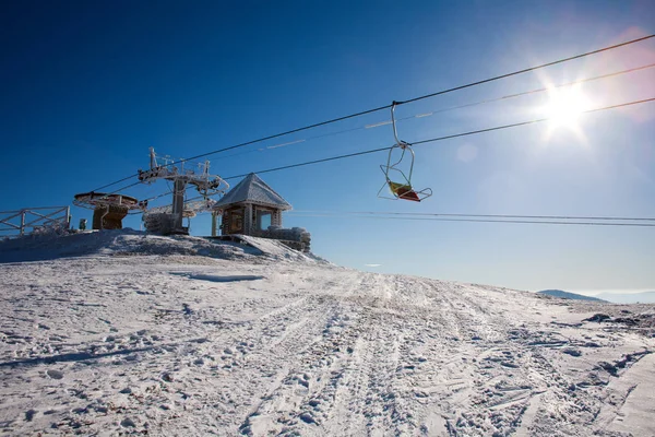 山区冬天下雪时的天空背景上的滑雪缆车 — 图库照片