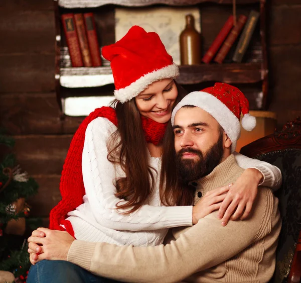 Pensive couple in New Year 's hats in Christmas at home — стоковое фото