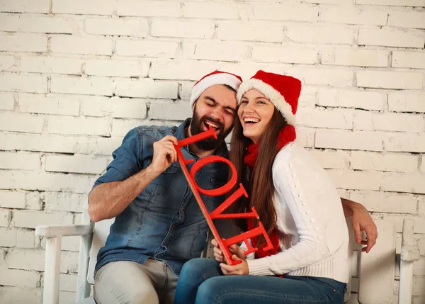 Любовная счастливая пара в рождественских люках на белой стене — стоковое фото