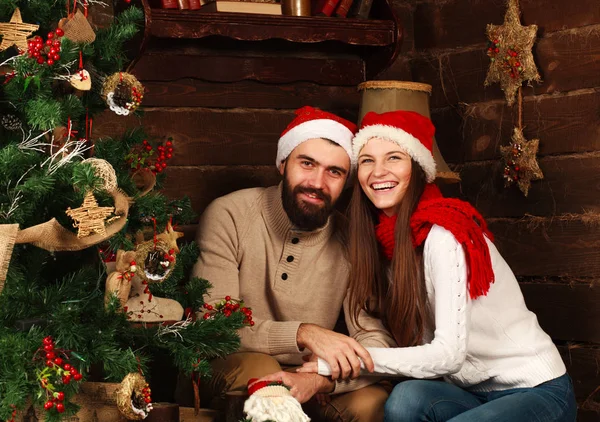 Happy couple in New Year 's hats in Christmas at home — стоковое фото