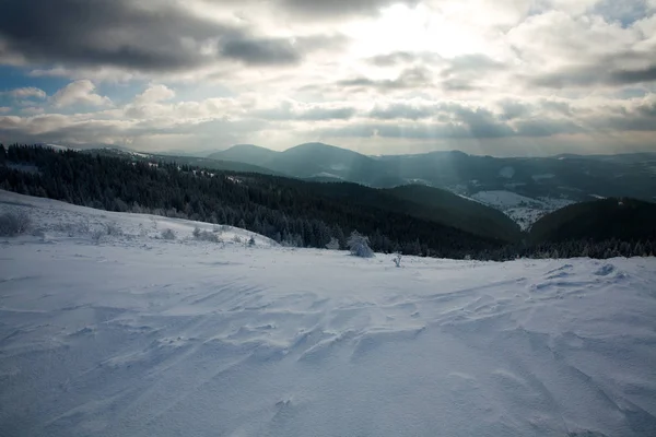 Paisaje invernal de montañas en rayos del sol poniente — Foto de Stock