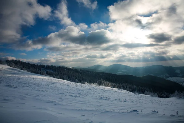 Paisaje invernal de montañas en rayos del sol poniente — Foto de Stock
