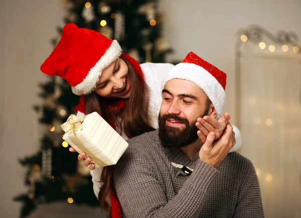 Счастливая девушка дарит своему парню рождественский подарок — стоковое фото