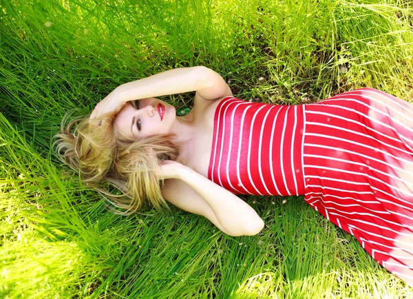 Beauté femme en robe couché sur la prairie verte dans l'herbe — Photo