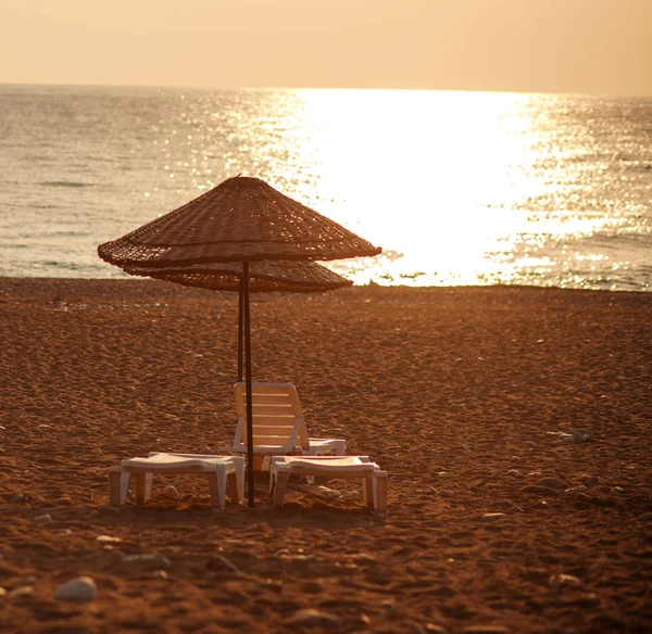 Snové pláže s lehátky pod slunečník na zapadajícího slunce — Stock fotografie