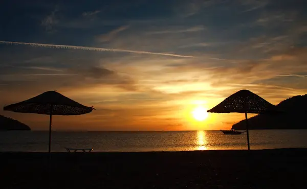 Parasol silhouette sur la côte sur fond de magnifique coucher de soleil — Photo