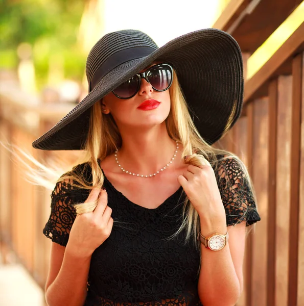 Glamorosa jovem senhora em grande chapéu preto no parque de verão — Fotografia de Stock