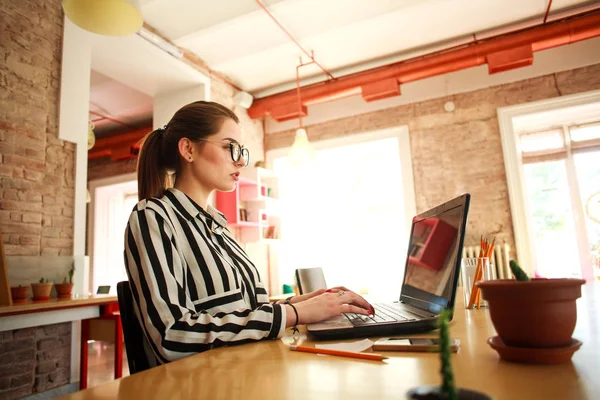 Closeup zakenvrouw aan tafel in kantoor werken bij laptop — Stockfoto