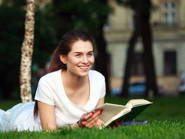 Student szczęśliwy dziewczyna w parku miejskiego z książką — Zdjęcie stockowe