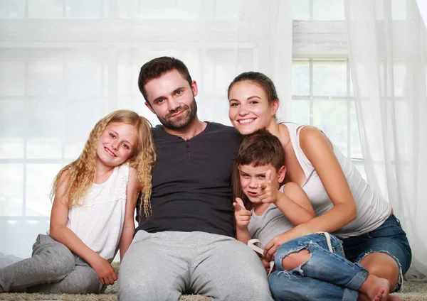 Des parents heureux et deux enfants à la maison — Photo