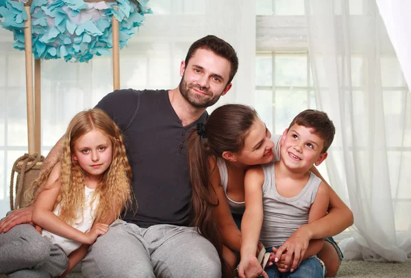 Des parents heureux et deux enfants à la maison — Photo