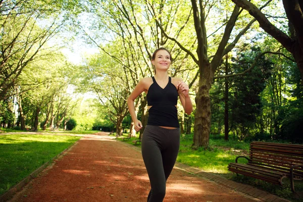 Mladá žena výkonu, běží v letním parku — Stock fotografie