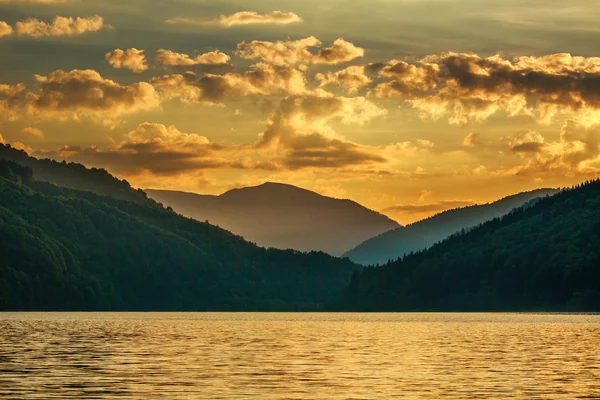 Montanha floresta lago no fundo dramático pôr do sol céu — Fotografia de Stock