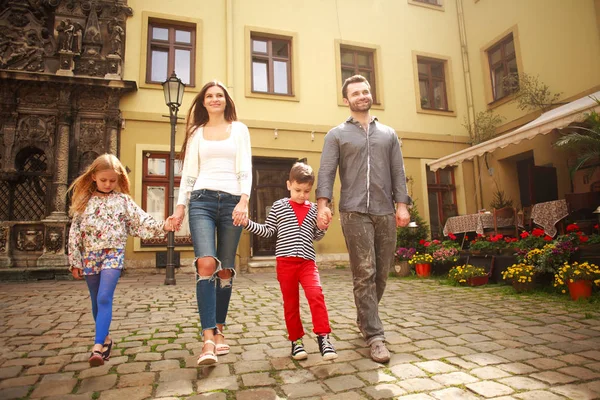 Giovane famiglia con bambini a piedi la strada della città turistica — Foto Stock