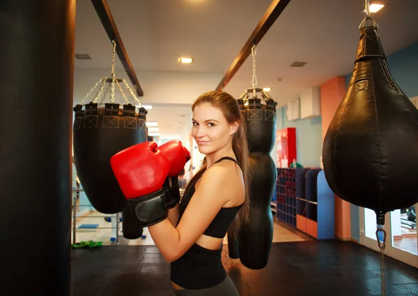 Sport giovane donna in boxe guanti rossi in palestra — Foto Stock