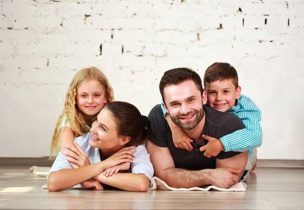 Mladí šťastné rodiny rodiče a dvě děti v domácím studiu — Stock fotografie