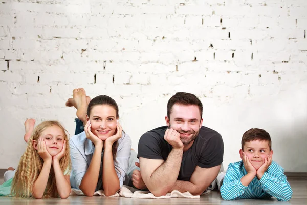 Jeunes parents heureux de la famille et deux enfants au studio à la maison — Photo