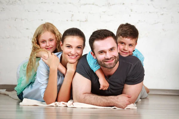 Joven familia feliz padres y dos niños en el estudio en casa — Foto de Stock