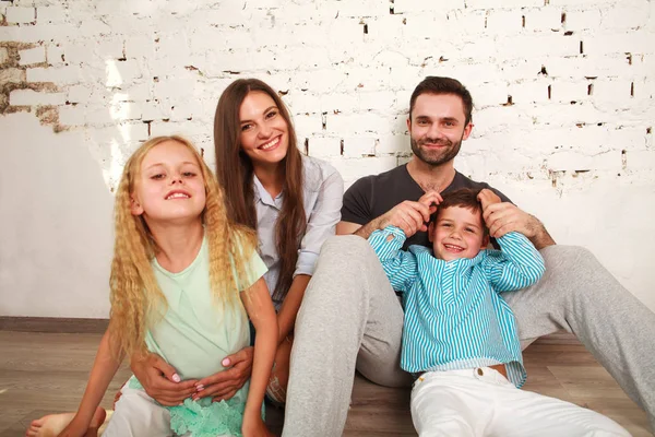 Joven familia feliz padres y dos niños en el estudio en casa —  Fotos de Stock