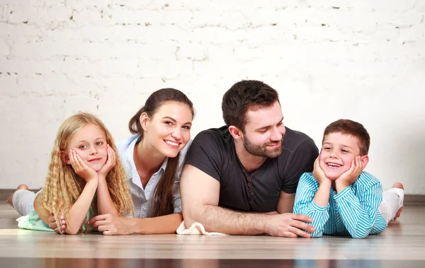 Joven familia feliz padres y dos niños en el estudio en casa —  Fotos de Stock