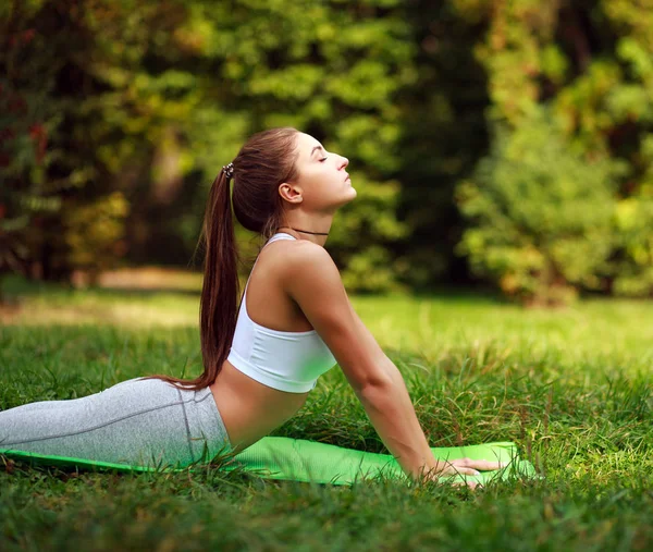 Vrouw doet fitness oefeningen in zomer park, training buiten — Stockfoto