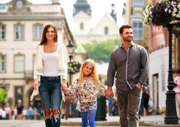 Pareja familiar con hija caminando por la calle de la ciudad turística — Foto de Stock