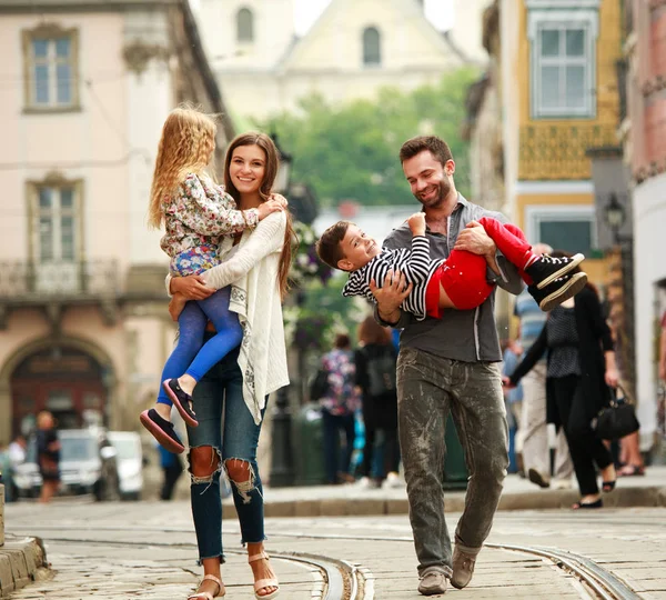 Família jovem com duas crianças andando rua velha cidade turística — Fotografia de Stock