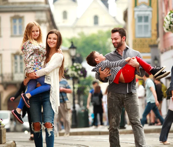 Familia joven con dos niños caminando calle vieja ciudad turística — Foto de Stock