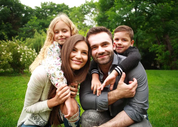 Portret van een glimlachende en gelukkige familie in stadspark — Stockfoto