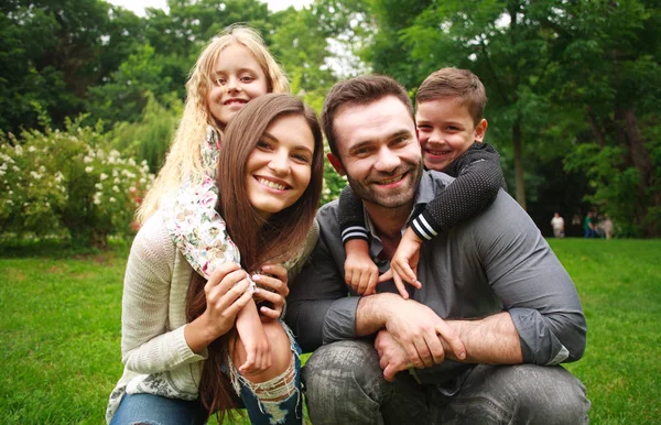 Portret van een glimlachende en gelukkige familie in stadspark — Stockfoto