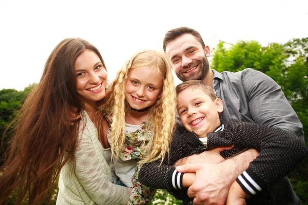 Felice famiglia gioiosa nel parco divertente giocare volo imitazione — Foto Stock