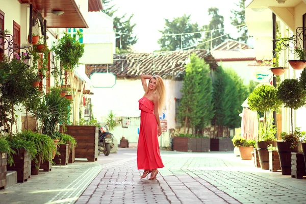 Молодая мечтательная женщина в платье гуляет по улицам туристического города — стоковое фото