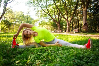 Sportif kadın yeşil C'de germe fitness egzersizleri yapıyor