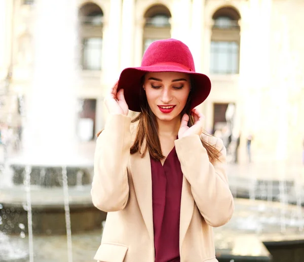 Jeune belle femme en manteau et chapeau violet sur la ville touristique de rue — Photo