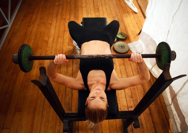 Entrenamiento de mujer fitness haciendo sentadillas con barra de pesas en el gimnasio — Foto de Stock