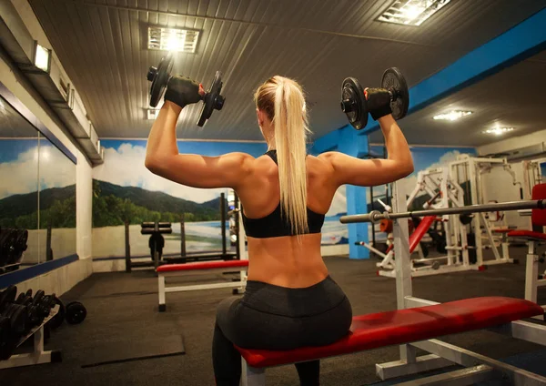 Αθλητική γυναίκα κάνει ασκήσεις στο γυμναστήριο άρσης αλτήρες — Φωτογραφία Αρχείου