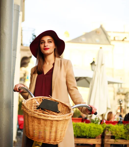 Jolie fille rêveuse avec vélo rétro sur la rue de la ville de printemps — Photo