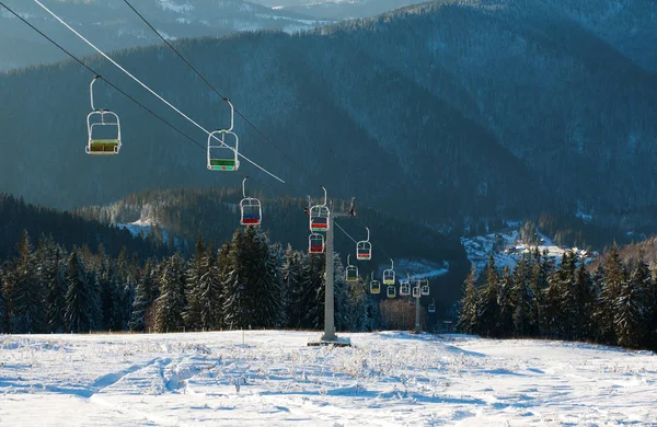 Skilift in winter besneeuwde bergen op pine forest achtergrond — Stockfoto