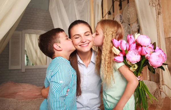 Kinderen feliciteer moeder geeft haar boeket van bloemen — Stockfoto
